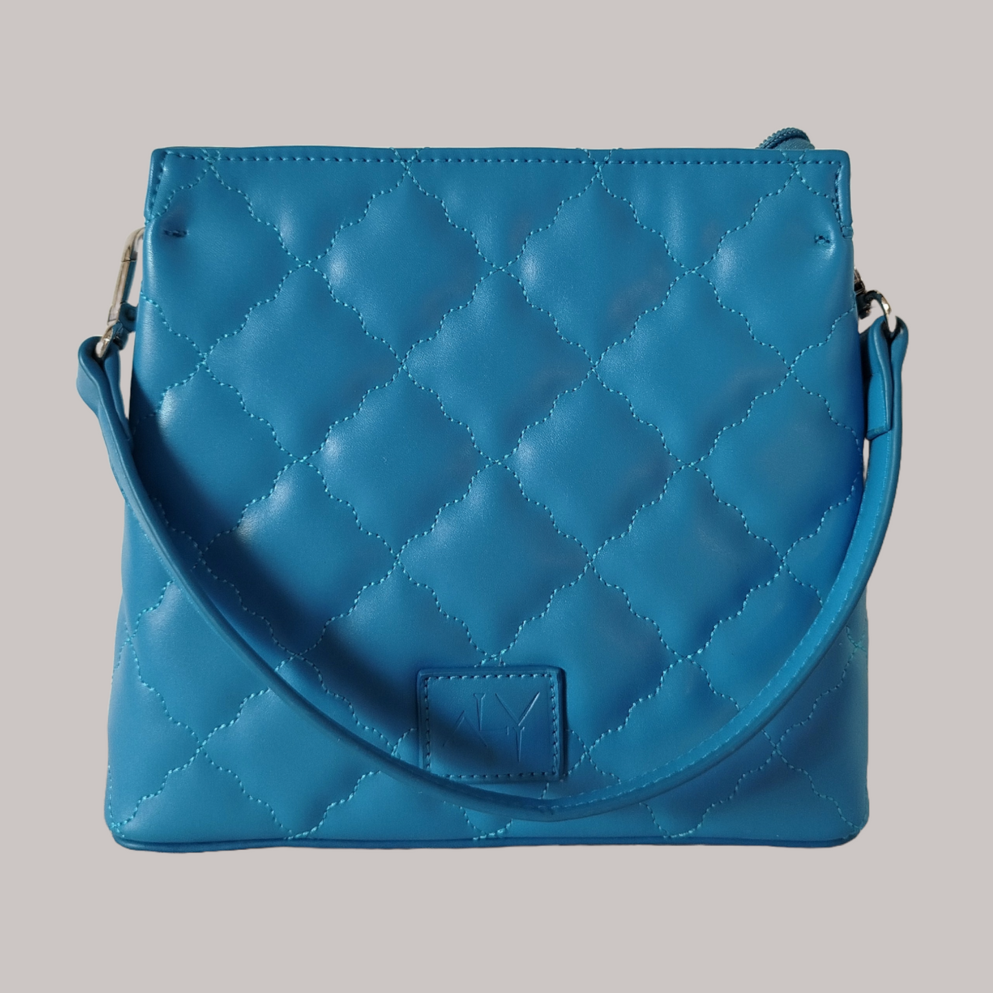 Blue quilted handbag with a wavy diamond stitch design and single handle