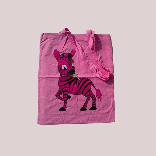 Pink tote bag with a cartoon zebra design on a light grey background